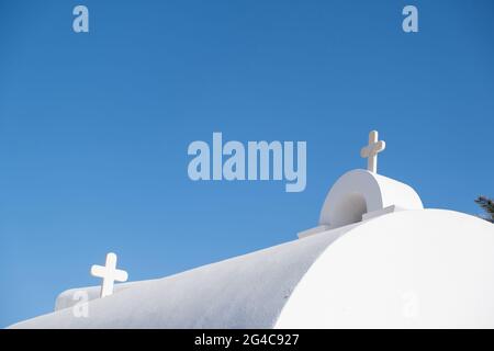 Kirche Detail, weiß und blau Farben. Kykladen.Griechenland. Weißes Kreuz auf dem Dach der griechischen Inselkirche, blauer Himmel im Hintergrund. Christentum Religion sy Stockfoto