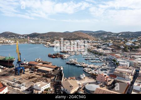 Syros Island, Griechenland, Blick auf den Hafen von Ermoupolis. Boote, die am Jachthafen anlegen. Industrieanlage Neorion Werft und Stadtbild, ruhig w Stockfoto