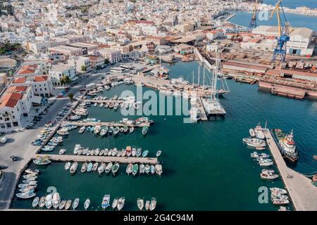 Syros Insel, Griechenland, Ermoupolis Stadt und Hafen Luftdrohne Ansicht. Boote, die am Jachthafen anlegen. Industrieanlage Neorion Werft und Stadtscap Stockfoto