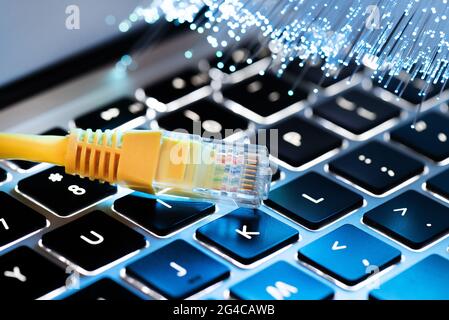 Internetkabel, RJ-45-Stecker auf Laptop-Tastatur. High-Speed-Glasfaser-Internet-Konzept Stockfoto