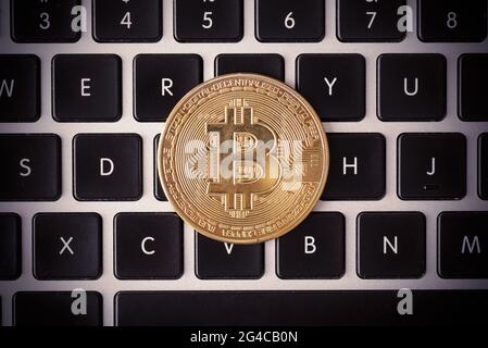 Goldene Münzen mit Bitcoin-Symbol auf der Laptop-Tastatur Stockfoto