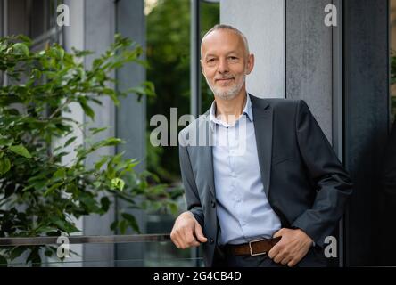 Der Mann in einem grauen Anzug lehnte sich auf den Handlauf. Stockfoto