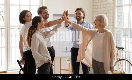 Glückliche, multiethnische Geschäftsleute, die bei der Besprechung hohe fünf geben Stockfoto