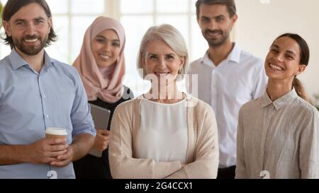 Porträt mit lächelnden, multiethnischen Mitarbeitern und einer reifen Führungskraft Stockfoto