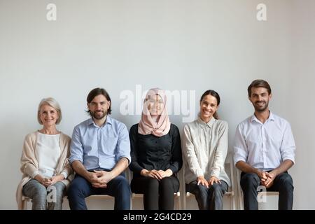Lächelnde Geschäftsleute Jobbewerber sitzen in der Warteschlange, warten Interview Stockfoto