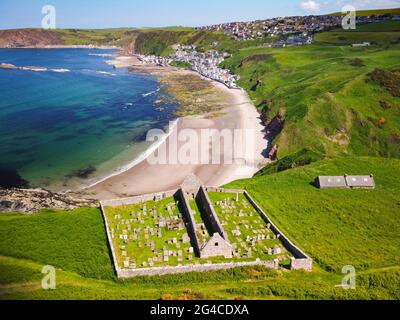 Luftaufnahme von der Drohne der St John’s Church und Kirkyard mit Blick auf das Dorf Gardenstown an der Moray firth Coast in Aberdeenshire, Schottland, Großbritannien Stockfoto