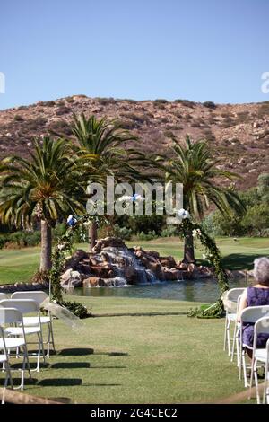 Runder Hochzeitsbogen mit Eukalyptusblättern, blauen Hortensien-Blüten mit Wasserfall und Bergen. Hochzeitszeremonie im Freien. Stockfoto