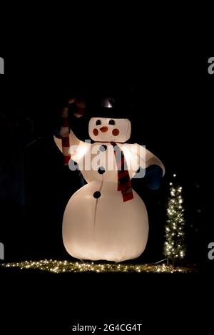 Aufblasbare Kunststoff weiß Schnee Mann Dekoration für weihnachten auf dem Hinterhof eines Hauses in der Nacht- saisonale Dekoration Konzept Stockfoto