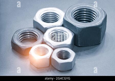 Metallmuttern in einer Reihe. Verchromte Schraubenmuttern. Werkzeuge für die Arbeit. Stockfoto