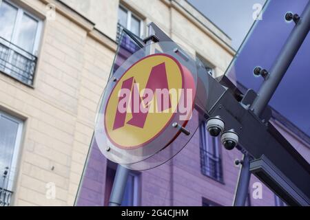 Warschau, Polen - Mai 21 2021. Firmenschild, Design Warsaw Metro am Eingang zur U-Bahn. Gelber runder Gesang mit M-Buchstabe und Pfeil. Stockfoto