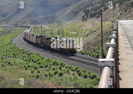 Union Pacific Lokomotive kommt um eine Kurve in Richtung einer Brücke. Stockfoto