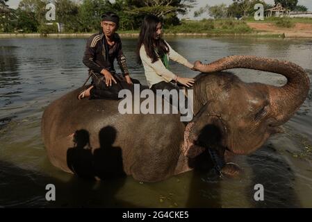 Ein Mahout und ein freiwilliger Arbeiter reiten auf einem Elefanten, nachdem er ihn im Sumatran Elephant Rehabilitation Center im Way Kambas National Park, Indonesien, gebadet hat. Stockfoto