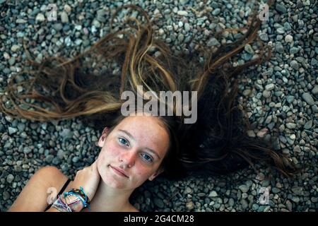 Das Porträt eines Teenagers liegt in Nahaufnahme auf dem Boden. Stockfoto