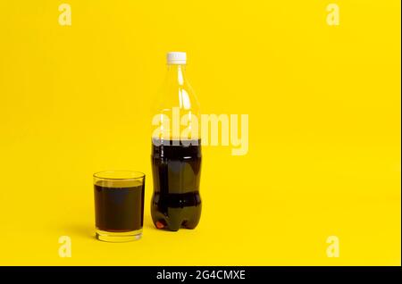 Schwarze Limonade in das Glas gegossen, Flasche Soda isoliert auf Farbhintergrund Stockfoto