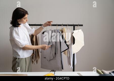Weibliche Modedesignerin halten Muster zum Nähen im Studio-Raum. Kreativer Prozess im Schneideratelierin Stockfoto