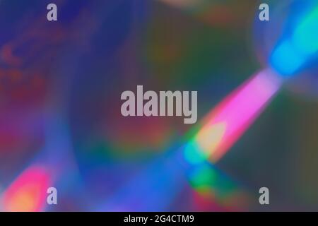 Defokussierter Hintergrund mit Filmtextur und farbigen Lichtern auf dunklem Hintergrund. Verwackelte Lichtreflexe in Regenbogenfarben für Fotoeffekte Stockfoto