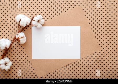 Weißes leeres Papier Karte Note Einladung mockup mit Blüte Baumwollblumen Zweig. Mockup-Rohling für Hochzeitskarte. Eleganter Raum mit Weiß Stockfoto