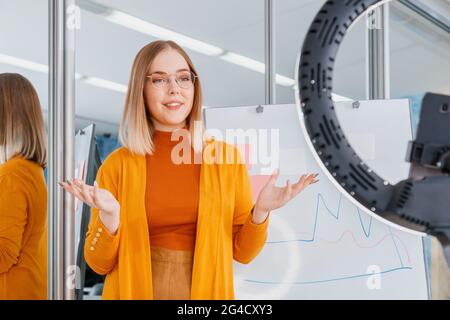 Online-Lehrer zeichnet Videostunden auf. Der Manager führt die Präsentation während eines Online-Meetings durch. Frau macht Grafik auf Whiteboard. Remote-Arbeit. Coaching von Mentor oder Stockfoto