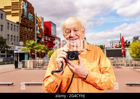 Hamburg, Deutschland. Juni 2021. Günter Zint, Nachbarschaftslegende und Fotograf, hält seine Kamera auf der Hamburger Reeperbahn in den Händen. Quelle: Axel Heimken/dpa/Alamy Live News Stockfoto