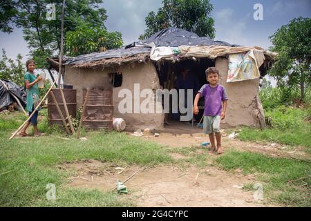 Armes indisches Kind, das an der Tür eines Schlammhauses in der ländlichen Gegend von uttarakhand, Indien, steht Stockfoto