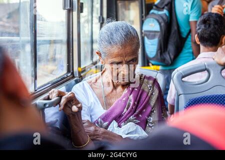 Ältere indische Frau, die Sari trägt und im Bus unterwegs ist, blickt nachdenklich in Gedanken verloren, Karnataka, Indien Stockfoto