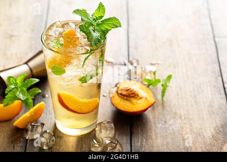 Sommerlicher Mojito-Cocktail aus Pfirsich mit frischen Minze-, Limetten- und Pfirsichscheiben Stockfoto