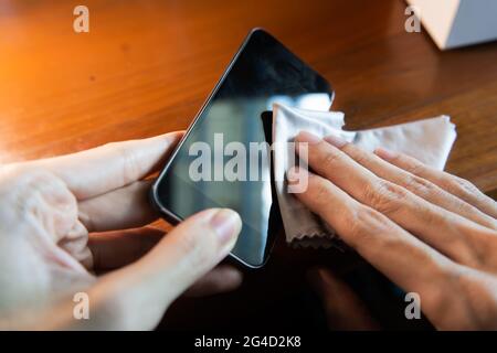 Cleaning smartphone screen with microfiber cloth Stockfoto