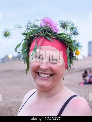 Brighton & Hove, Großbritannien. 21. JUNI 2021 EIN Sonnenwende-Schwimmer, der eine Blumenkrone trägt, bereitet sich darauf vor, den längsten Tag bei Sonnenaufgang mit einem Bad unter bewölktem Himmel zu feiern. Wetter in Großbritannien. Foto ©Julia Claxton Credit: Julia Claxton/Alamy Live News Stockfoto