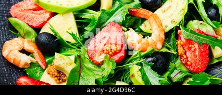 Diätsalat mit Garnelen, Erdbeeren, Avocado und Kräutern. Hintergrund des Essens, langes Banner Stockfoto