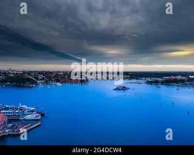 Panorama Drohnenaufnahme von Sydney CBD Ansichten NSW Australien. Dunkle Wolken wunderschönes türkisblaues Wasser Wohn- und Geschäftsgebäude. Stockfoto