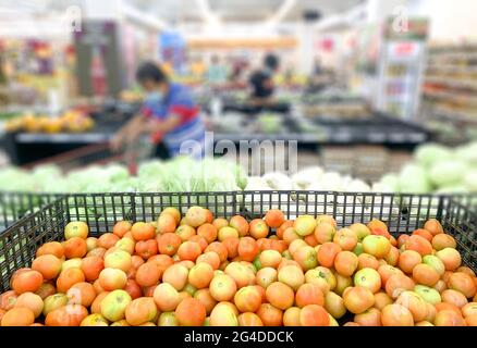 Einkaufen im Supermarkt Lebensmittelbereich, entkokkt. Selektiver Fokus auf Tomaten. Stockfoto