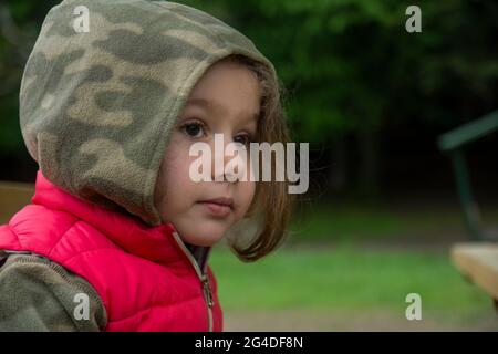 Im Frühjahr wandert das kleine Mädchen im Camouflage-Hoodie im Abant-Nationalpark. Selective Focus Girl Stockfoto