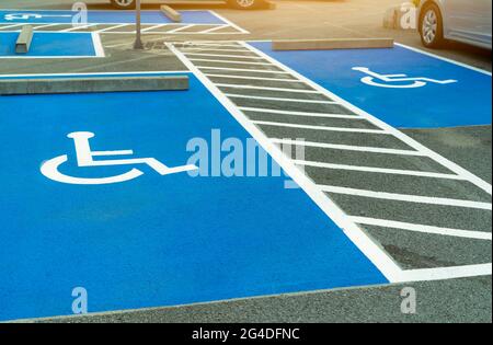 Asphaltparkplatz für behinderte Fahrer im Supermarkt oder Einkaufszentrum reserviert. Parkplatz für Behinderte. Farbe für Rollstuhlfahrer Stockfoto