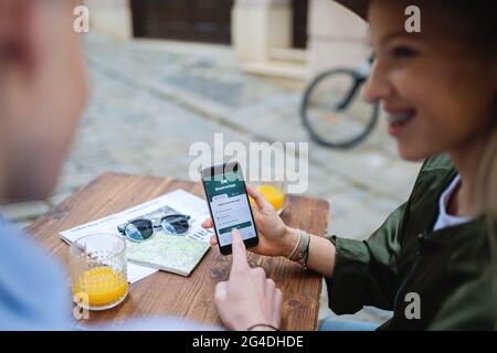 Nicht erkennbare Paar Reisende mit Smartphone auf der Suche nach einer Unterkunft in der Stadt im Urlaub. Stockfoto