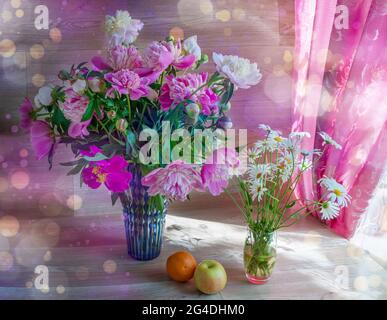Schönes Stillleben mit weißen und rosa Pfingstrosen in einer blauen Vase und Gänseblümchen Stockfoto