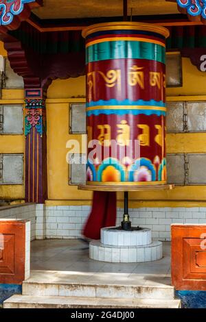 Buddhistischer Mönch rotiert großes Gebetsrad Stockfoto