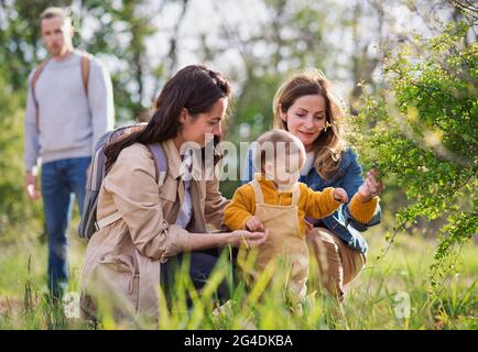 Kleines Kleinkind mit Eltern und Großeltern auf einem Spaziergang im Freien in der Natur. Stockfoto