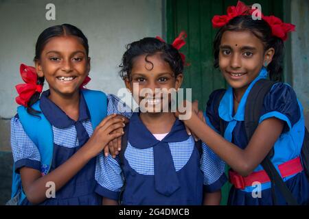 Lächelnd drei indische ländliche Schulmädchen tragen Schuluniform stehen in der Schule Stockfoto