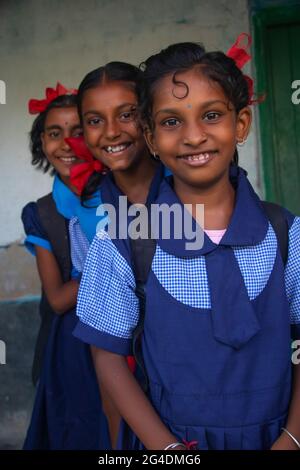 Lächelnd drei indische ländliche Schulmädchen tragen Schuluniform stehen in der Schule Stockfoto