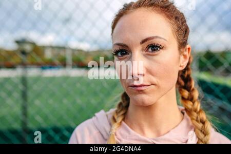 Seriöse junge Sportlerin mit Boxer Zöpfe suchen Kamera Stockfoto