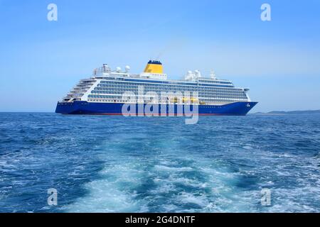 Schiff vor Anker im St. Peter Port, Guernsey. Großes Schiff mit blauem Rumpf und gelbem Trichter vor der Küste der Kanalinseln, Großbritannien. Stockfoto