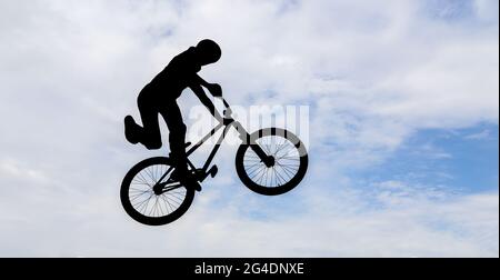 Silhouette eines Mannes, der einen Sprung mit einem bmx-Fahrrad macht. Stockfoto