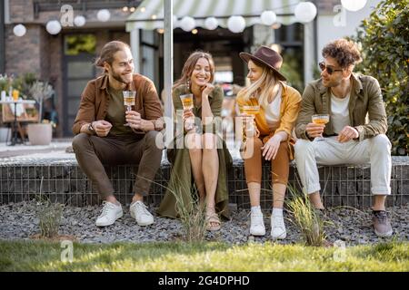 Freunde treffen sich auf einer Veranda eines Landhauses Stockfoto