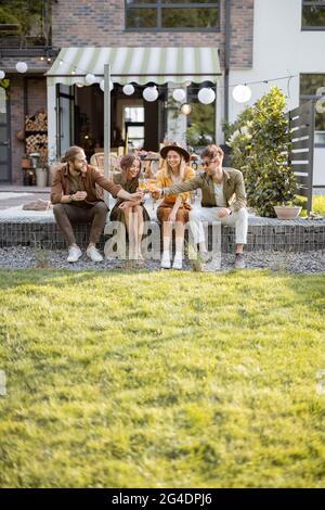 Freunde treffen sich auf einer Veranda eines Landhauses Stockfoto