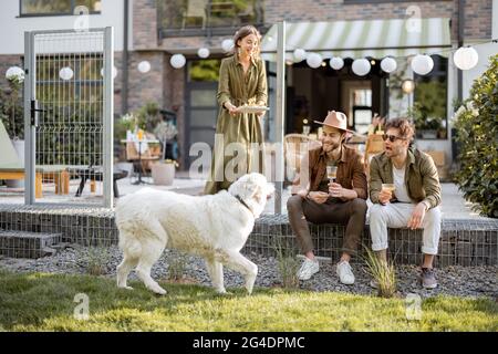 Freunde treffen sich auf einer Veranda eines Landhauses Stockfoto