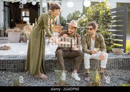 Freunde treffen sich auf einer Veranda eines Landhauses Stockfoto