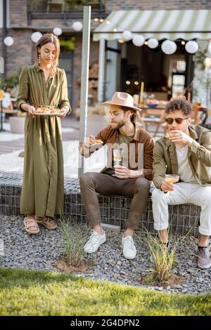 Freunde treffen sich auf einer Veranda eines Landhauses Stockfoto