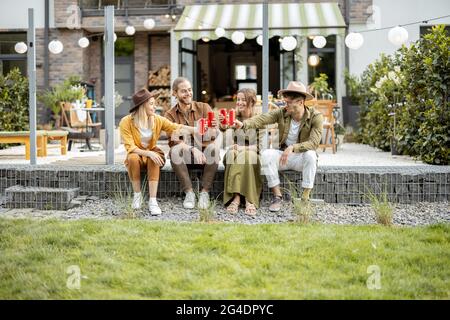 Freunde treffen sich auf einer Veranda eines Landhauses Stockfoto