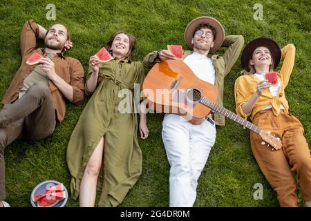 Freunde liegen zusammen auf dem grünen Rasen Stockfoto