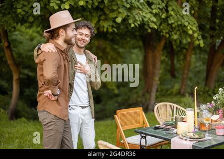 Zwei männliche Freunde sprechen während eines Mittagessens in der Natur Stockfoto